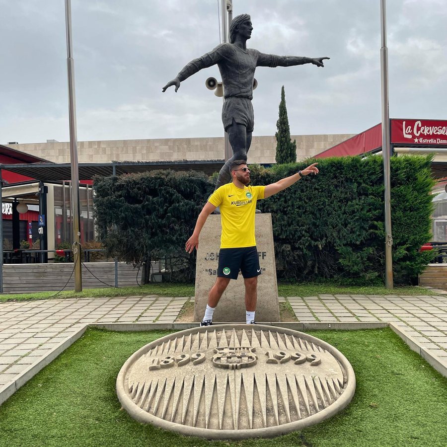 Maillot gardien Kurdistan jaune porté devant la statue d'une légende du football à Barcelone